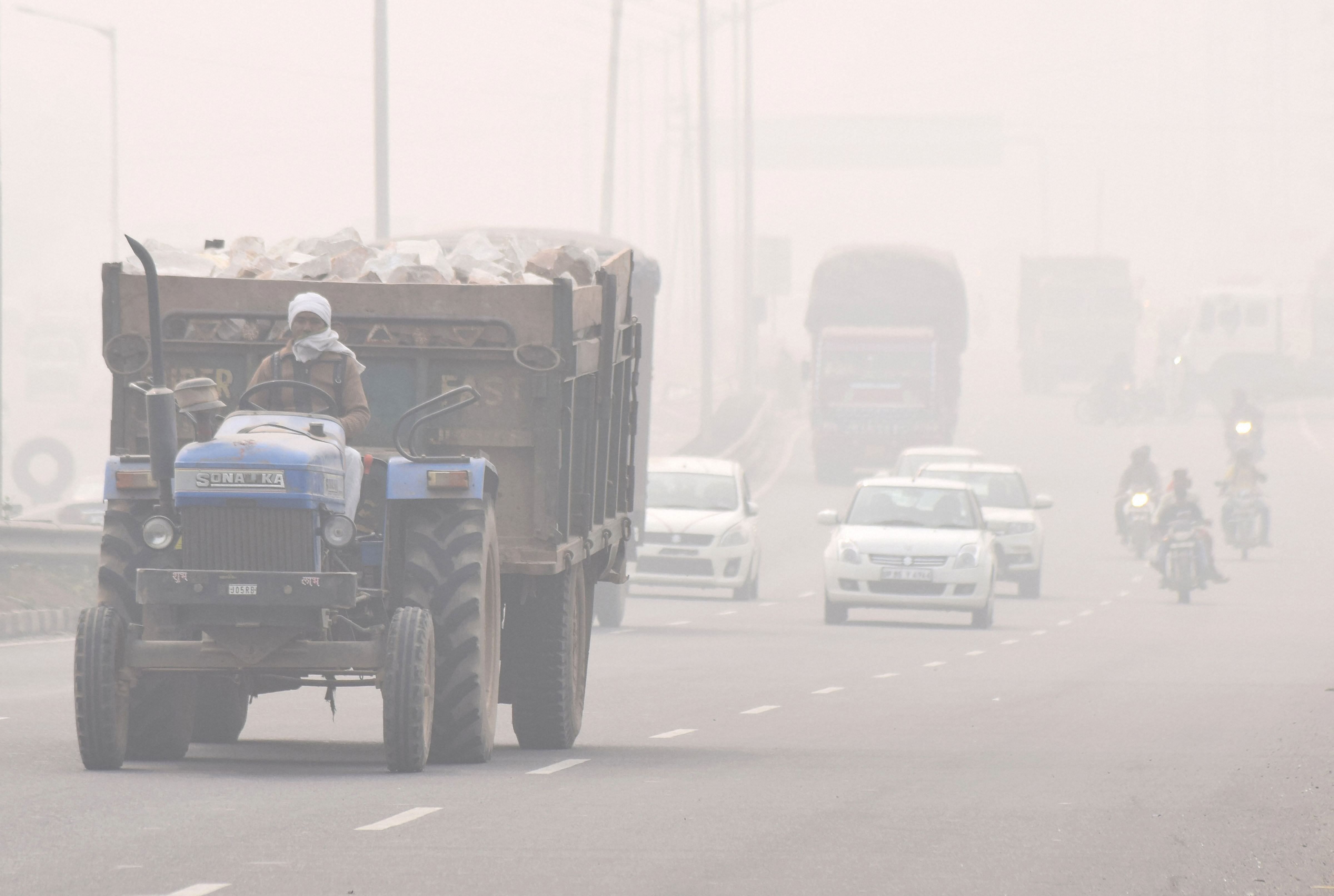Vehicles ply on NH-2 amid thick smog, in Mathura. (PTI Photo)