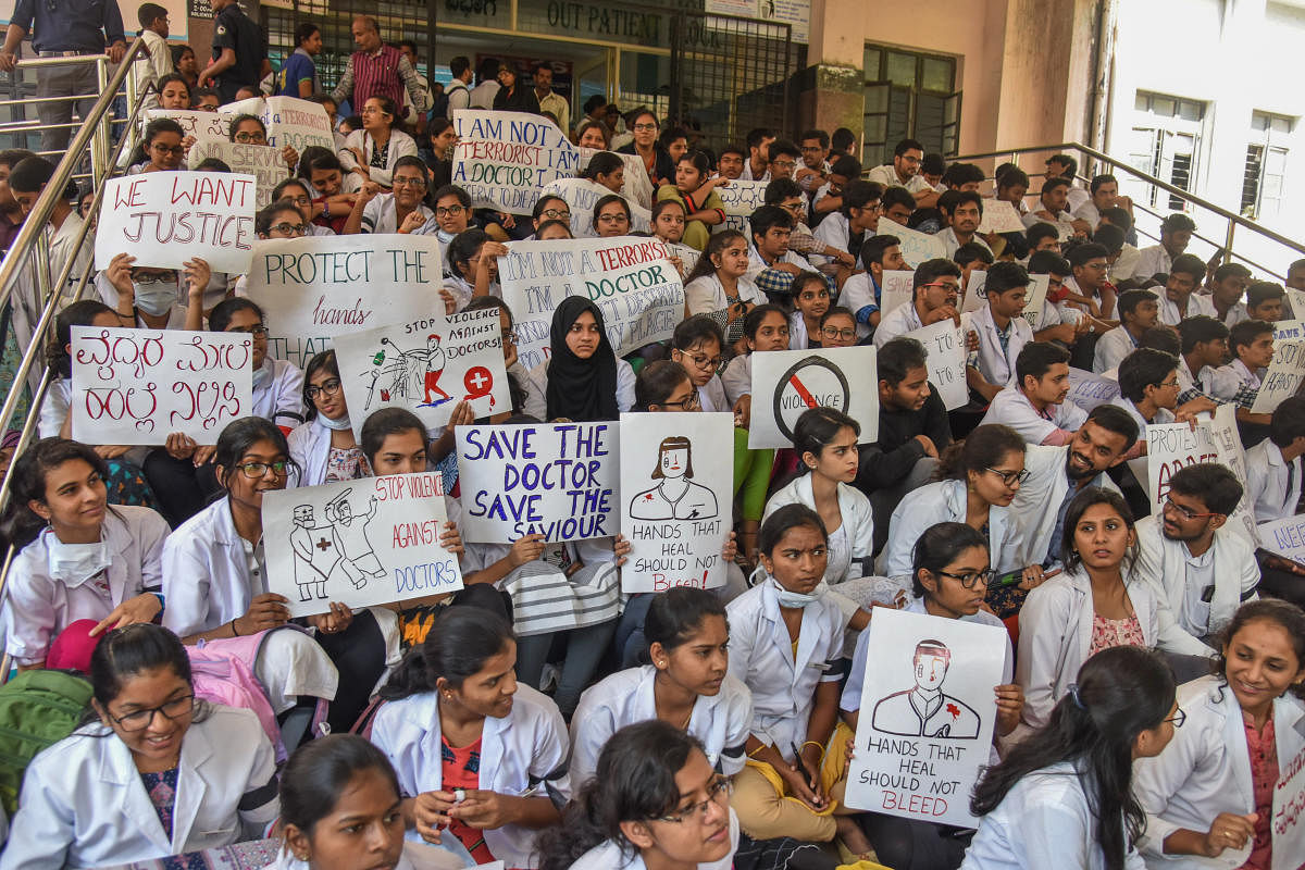 Resident doctors and postgraduate medical students protest outside the OPD of Victoria Hospital on Monday. DH PHOTO/S K DINESH