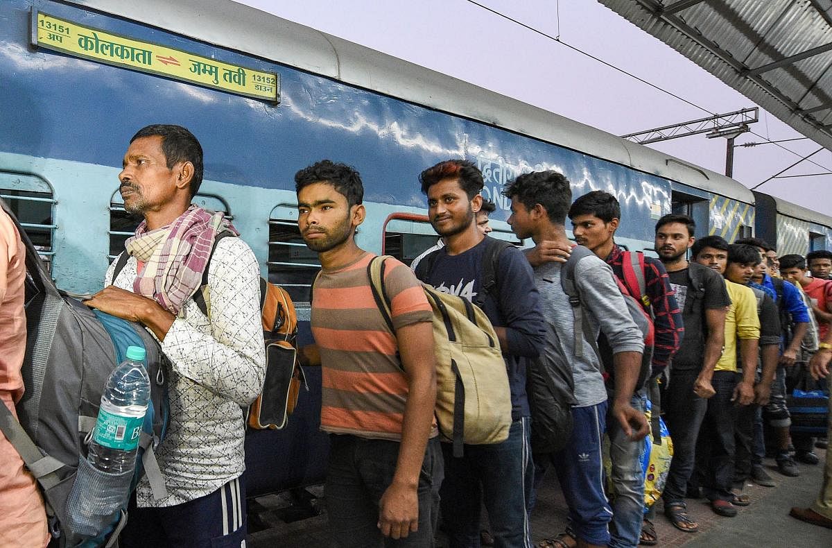 Workers arrive at the station from Jammu and Kashmir, in Kolkata. (PTI Photo)