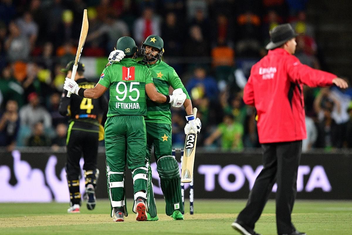 Pakistan's Imad Wasim (C) greets teammate Iftikhar Ahmed for his half century (50 runs) during the second Twenty20 match between Australia and Pakistan at the Manuka Oval in Canberra on November 5, 2019. (AFP)