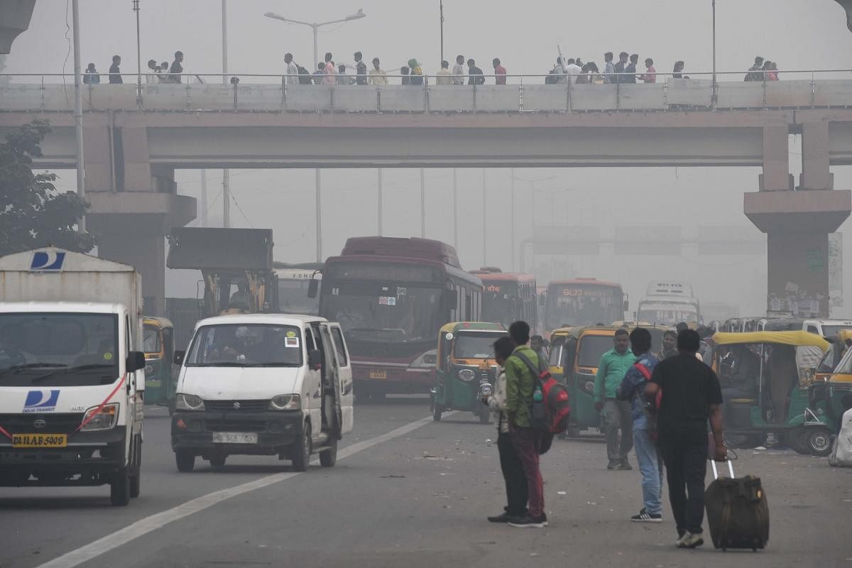 People make their way on a street in smoggy conditions in New Delhi. (AFP Photo)