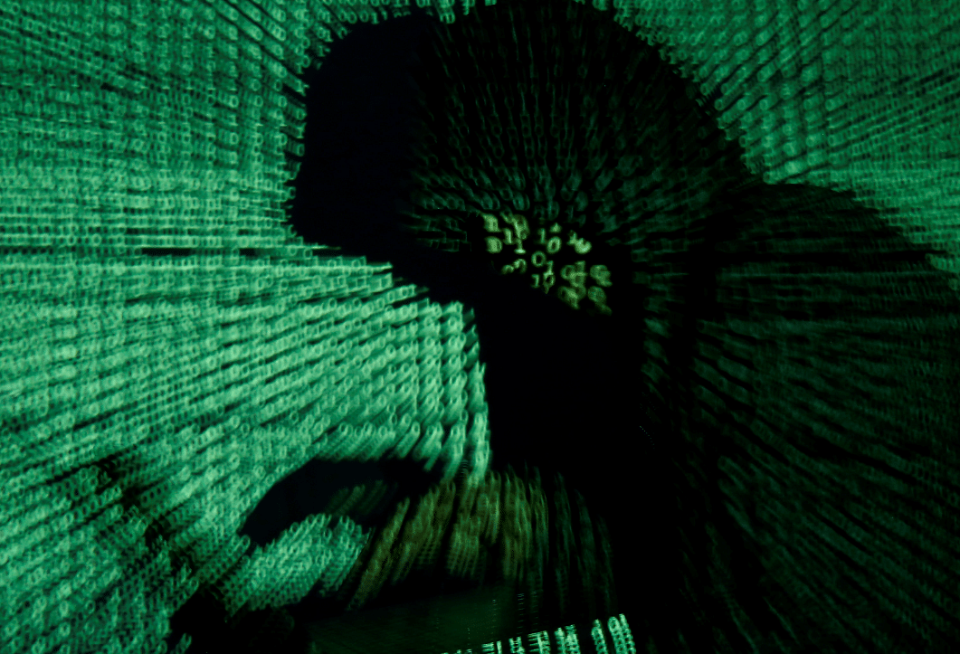 Man holds laptop computer as cyber code is projected on him in this illustration picture (Reuters File Photo)
