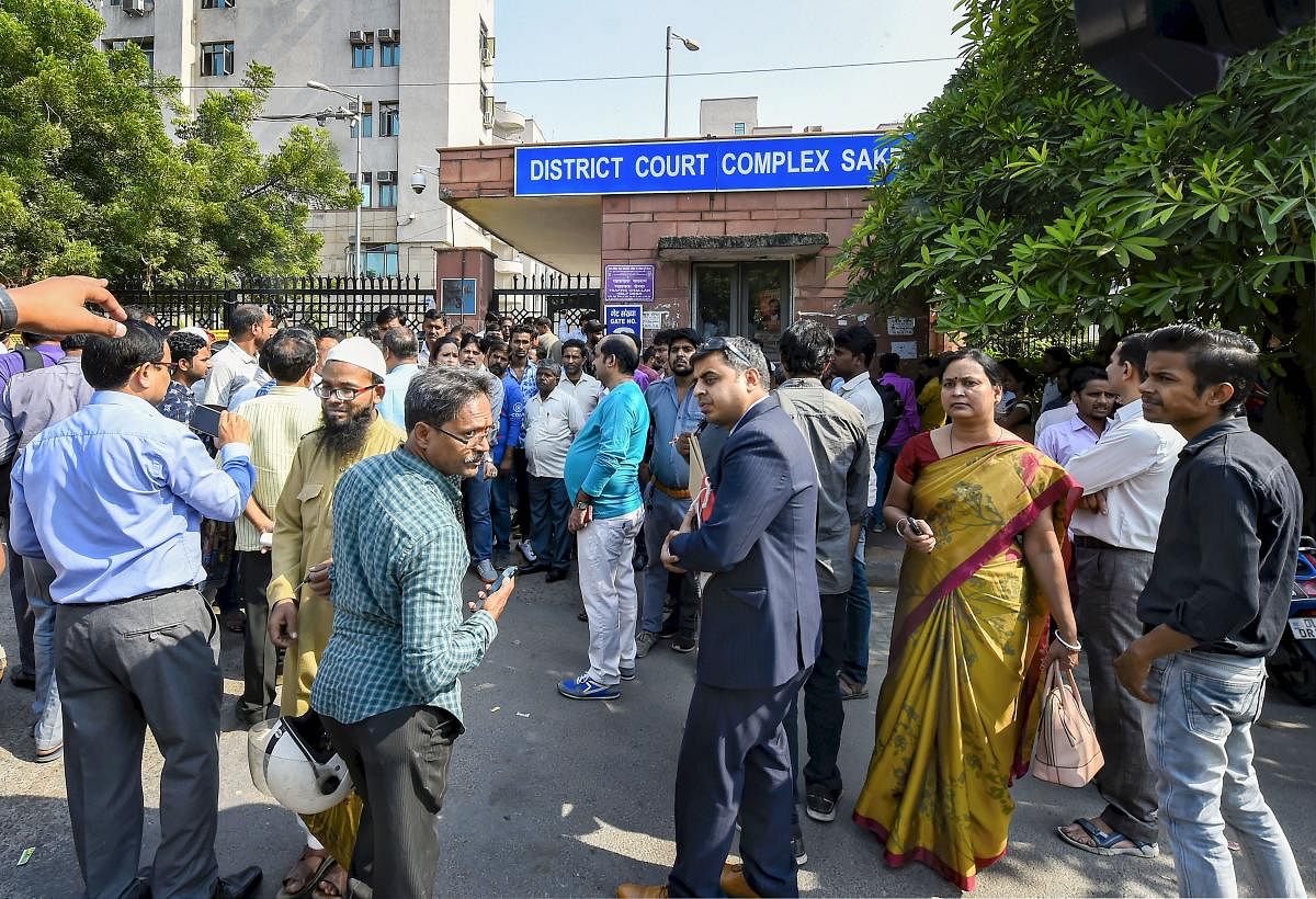 People wait outside Saket courts during lawyers protest inside the court premises over last week's incident of clashes between lawyers and police at Tis Hazari Court complex, in New Delhi, Wednesday, Nov. 6, 2019. (PTI Photo/Kamal Singh)