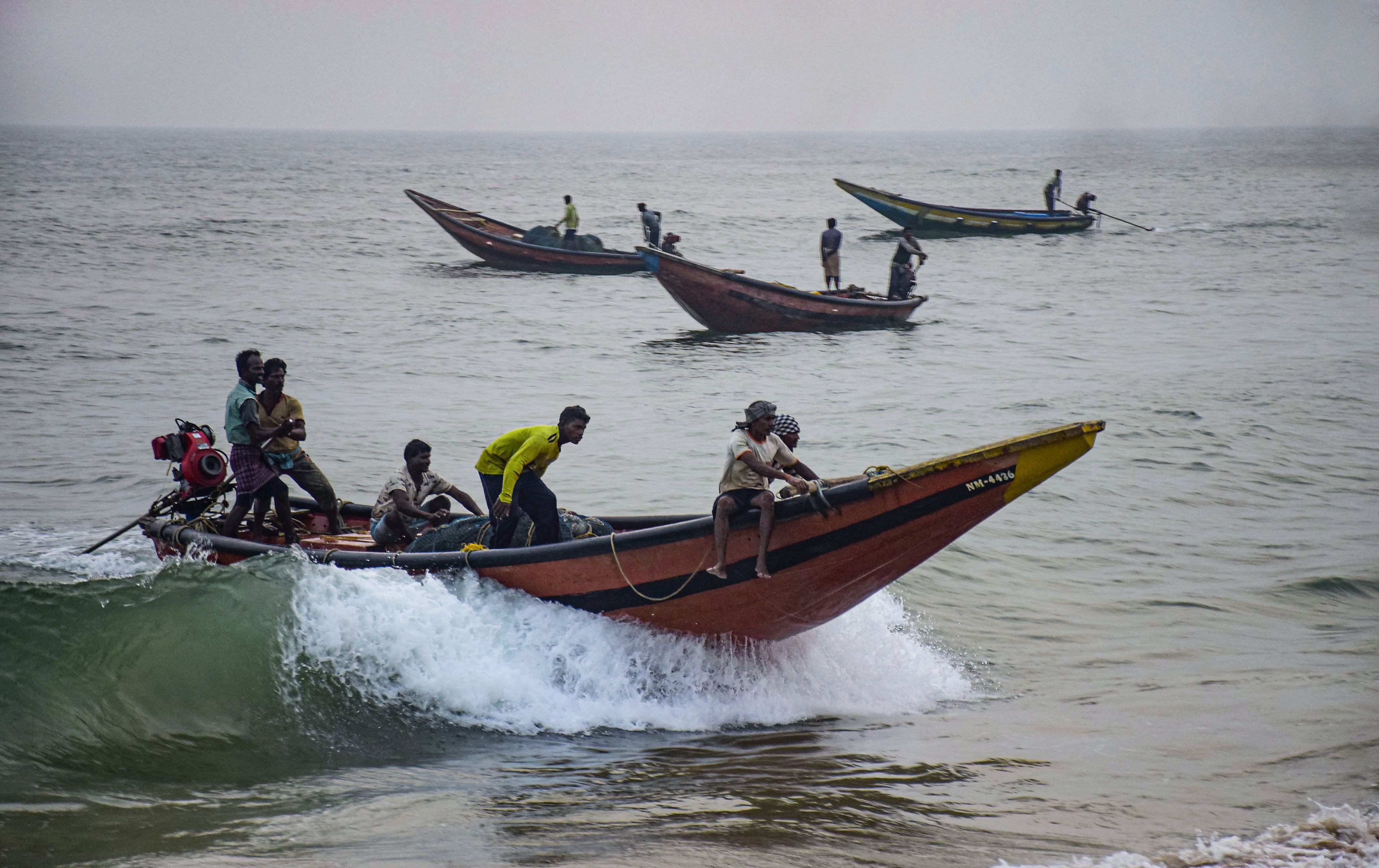 Fishermen take their boats to a safe harbour from the sea following Cyclone Bulbul warning, in Puri. (PTI Photo)