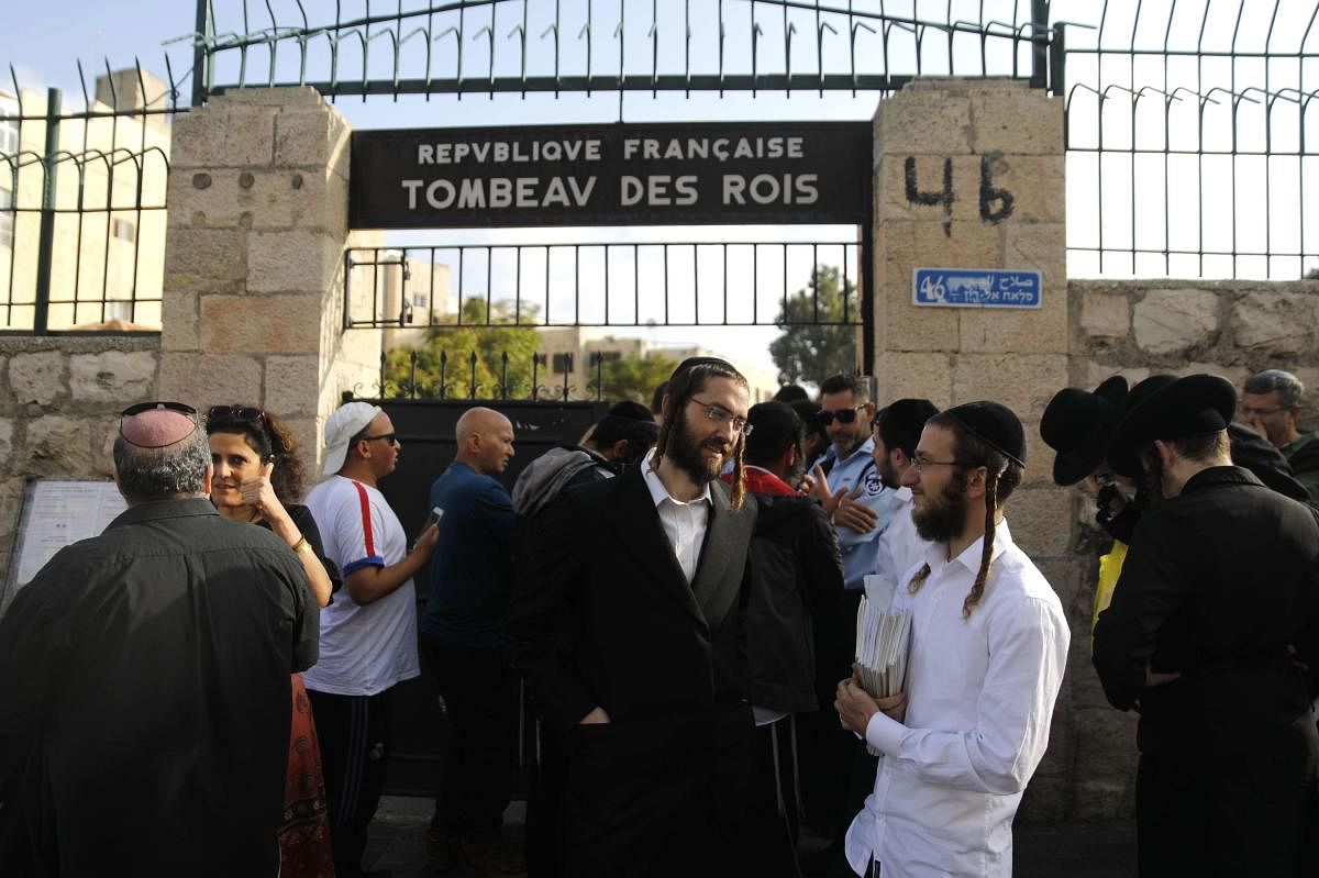 Ultra-Orthodox Jews wait among other visitors to enter the Tombs of the Kings. (Photo by MENAHEM KAHANA / AFP)