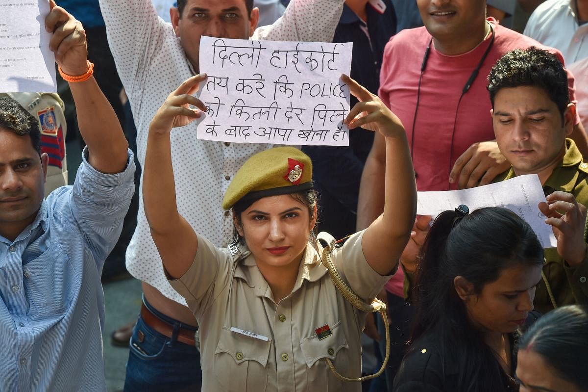 A Delhi Police woman displays a placard during a protest against the alleged repeated incidents of alleged violence against them by lawyers, in New Delhi, Tuesday, Nov. 5, 2019. (PTI Photo)