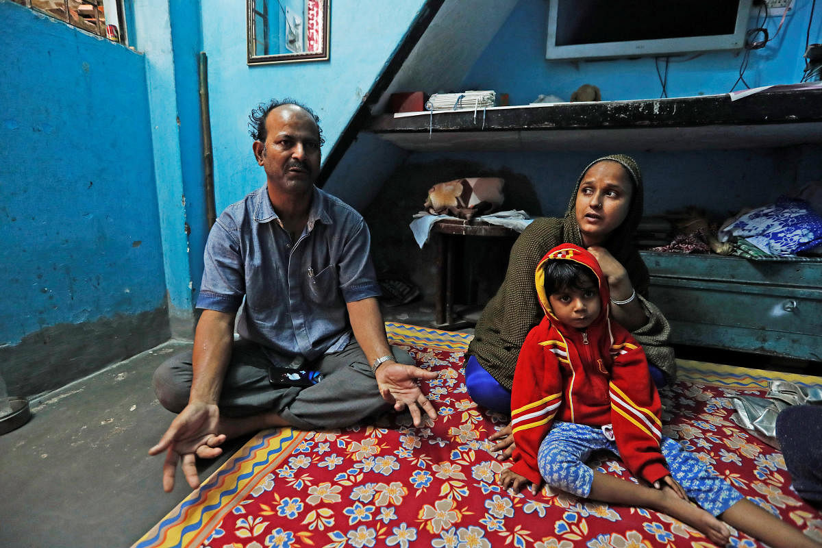Fareeda and her husband Abdul Hanif sit with their four-year-old daughter inside their house in New Delhi, India. ( REUTERS/Adnan Abidi)