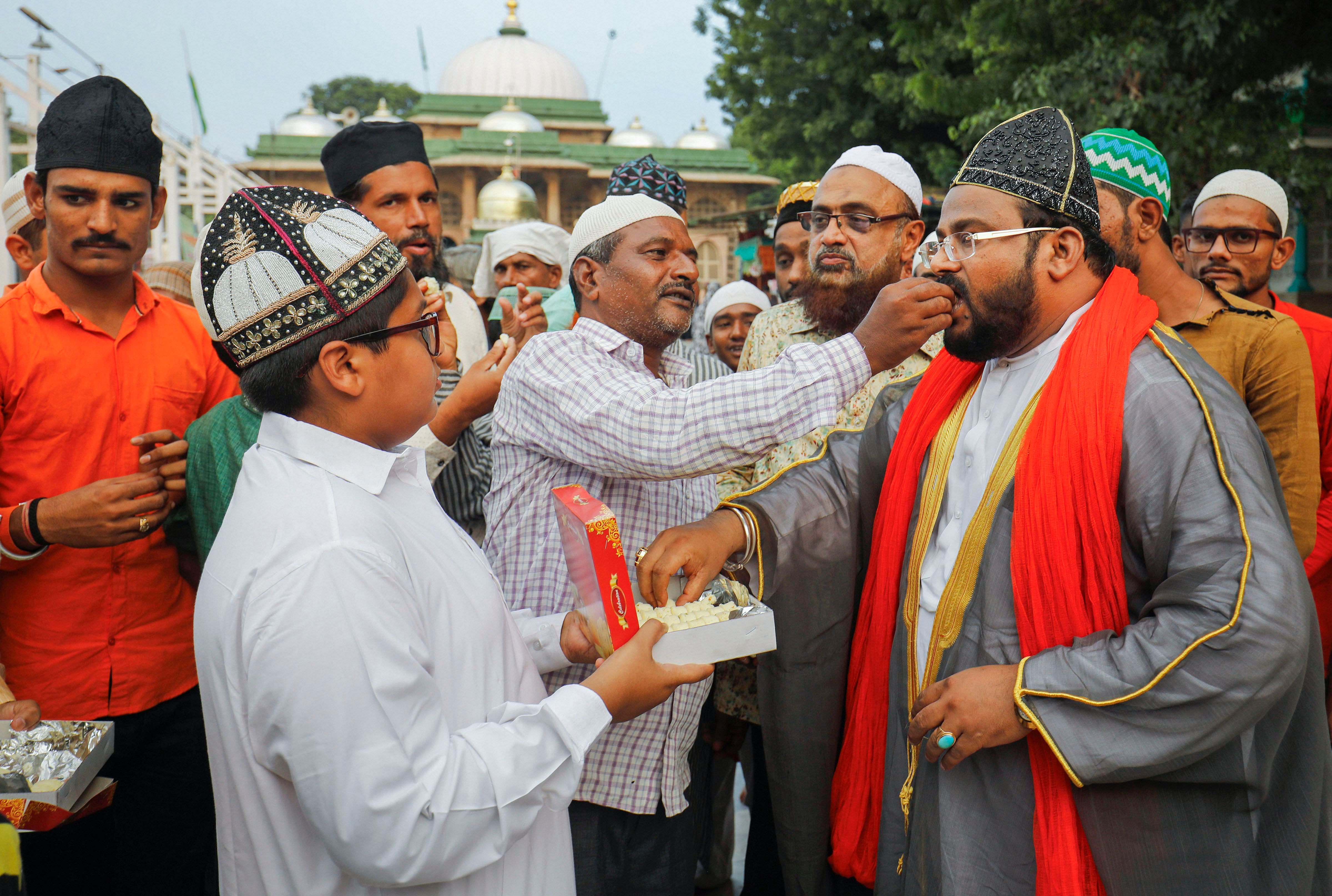 Muslims offer sweets to each other after Supreme Court's verdict outside the Shah-e-alam shrine in Ahmedabad, India, Saturday, Nov. 9, 2019. The apex court on Saturday cleared the way for the construction of a Ram Temple at the disputed site at Ayodhya, and directed the Centre to allot a 5-acre plot to the Sunni Waqf Board for building a mosque. (PTI Photo)