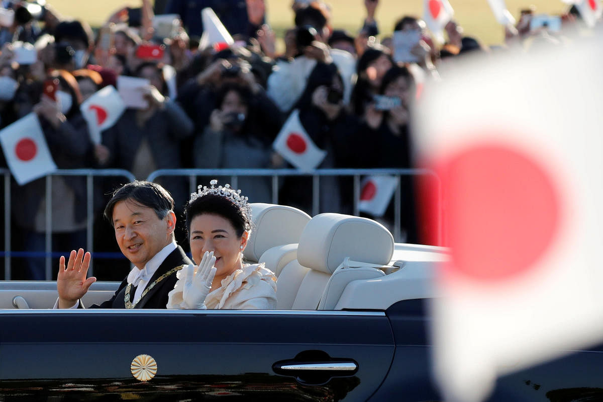 Japan's Emperor Naruhito and Empress Masako wave to well-wishers during their royal parade to mark the enthronement of Japanese Emperor Naruhito in Tokyo. Reuters