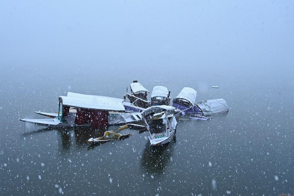 Boats are covered in snow in Dal lake during a first snowfall in Srinagar. (Photo by Tauseef MUSTAFA / AFP)