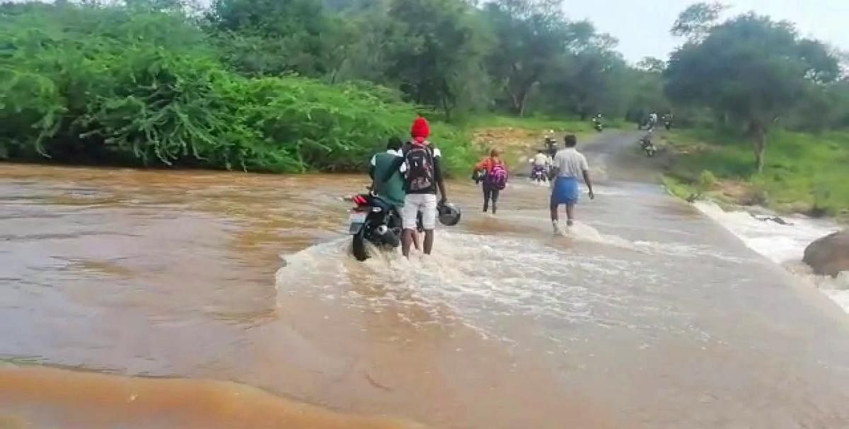 With heavy rains, the Gopinatham dam has filled to its brim and the water is seen overflowing on to the road that connects Hogenakkal falls, at several places, causing inconvenience to the road users. (DH photo)