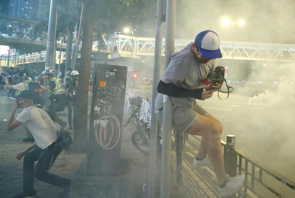 People react to the tear gas during an anti-government demonstration in Hong Kong, China. (Photo by Reuters)