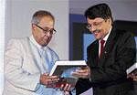 Finance Minister Pranab Mukherjee receives a copy of 'Bankers Beacon' by Union Bank of India CMD M V Nair (right) at the 92nd foundation day function of the bank in New Delhi on Thursday. PTI