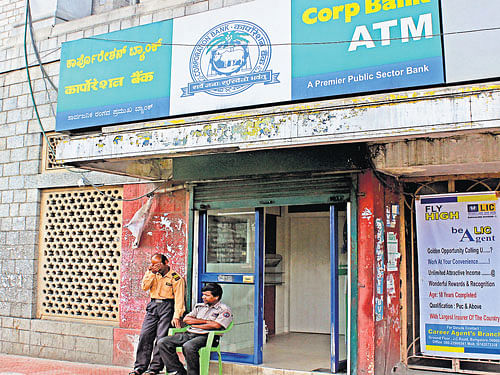 Guards man the Corporation Bank ATM in Bengaluru on Tuesday. A woman was attacked in the kiosk November last year. The attacker is yet to be nabbed. DH PHOTO