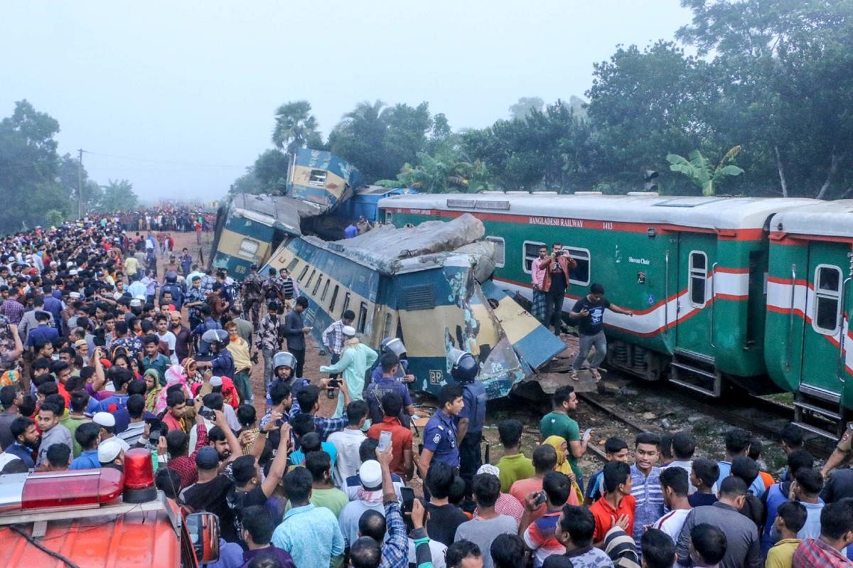 Bystanders look on after a train collided with another train in Brahmanbaria some 130 kms from Dhaka on November 12, 2019. - Two packed trains rammed into each other in Bangladesh on November 12, killing at least 16 people and injuring nearly 60 others, police said. (Photo by STR / AFP)