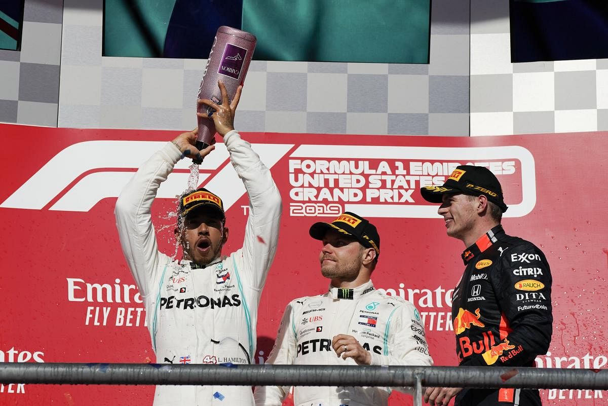 Mercedes driver Lewis Hamilton, left, of Britain, celebrates as Mercedes driver Valtteri Bottas, middle, of Finland, and Red Bull driver Max Verstappen, of the Netherlands, watch following the Formula One U.S. Grand Prix auto race at the Circuit of the Americas. AP/PTI
