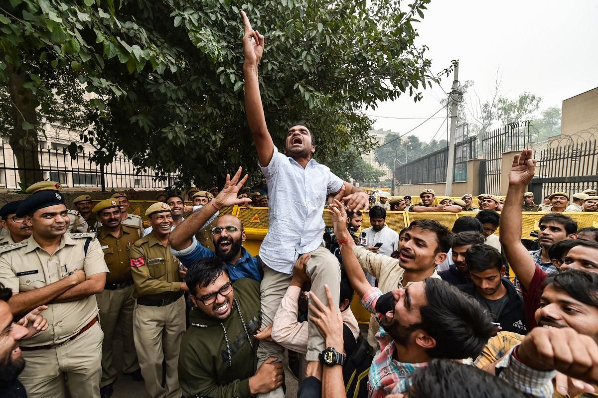 JNU students celebrate after partial roll-back in the fee hike by the University administration. (PTI Photo)