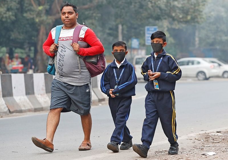 Schoolboys wearing protective masks walk towards their school on a smoggy morning in New Delhi. (PTI Photo)