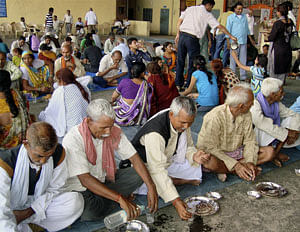 Flood victims have lunch at a relief camp in Chamoli on Sunday. PTI File Photo
