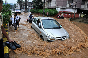 Guwahati: Vehicles move through a waterlogged road after a heavy shower in Guwahati on Saturday. PTI Photo