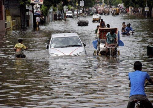 Vehicles move through a waterlogged roads after heavy rains in Patna on Saturday. PTI photo