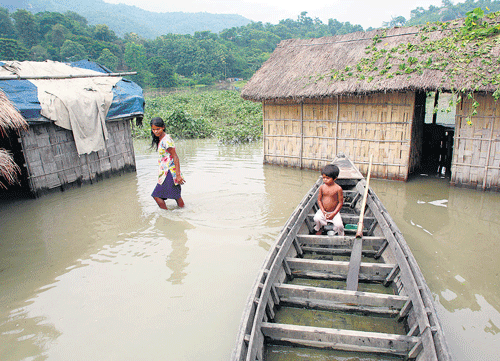 Children amidst flood-affected houses in Ashigarh village, about 70 kilometres away from Guwahati, Assam, on Tuesday.  AP photo