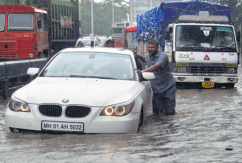 Vehicles move slowly at a waterlogged road after heavy rains in Mumbai on Thursday. PTI  photo