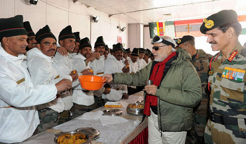 Prime Minister Narendra Modi shares sweets with the officers and jawans of armed forces in Siachen on Thursday. PTI