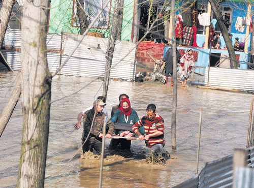 RESCUE EFFORT:AJ&K policemanand a civilian rescue awoman after floodwater entered the Hamadania Colony Bemina in Srinagar on Monday. PTI