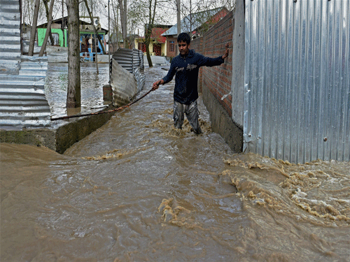 A boy moves towards safer place from the flood hit Hamdania Colony in Srinagar on Monday. The flood hits Kashmir valley again following incessent rains. PTI Photo