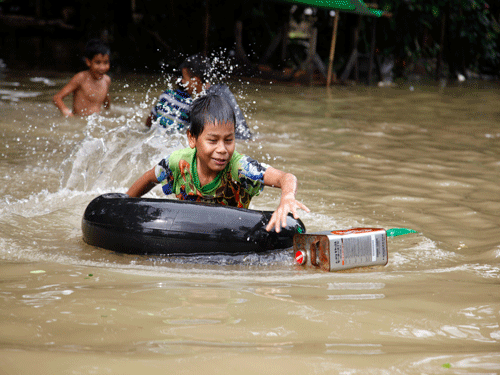 A boy rides inner tube as he swims in a flooded road in Bago, 80 kilometers (50 miles) northeast of Yangon, Myanmar, AP photo