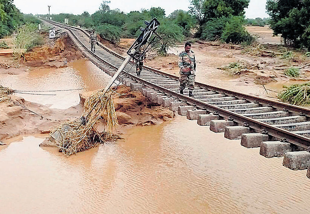 Deluge and disorder: Security personnel inspect a railway track after floodwaters washed away the supporting embankment following incessant rainfall in Imphal
