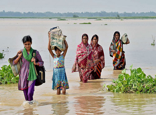 People shift with their belongings from a flooded area in Burdwan district of West Bengal on Monday. PTI