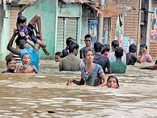 People wade through a water-logged road after a high tide on river Ganga at Kalighat in Kolkata on Monday; PTI file photo