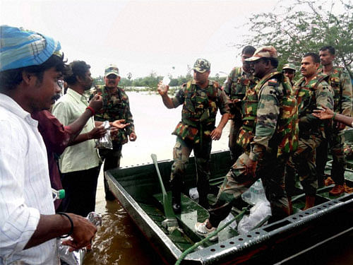 Army personnel distribute food packets to flood affected people in Chennai on Friday. PTI Photo