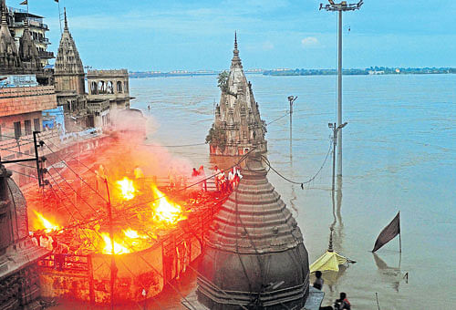in distress: People hold a cremation ceremony on the roof of a building  in Varanasi on Tuesday. Varanasi has been forced to halt cremations along the banks of the river Ganga following floods, an official said. AFP