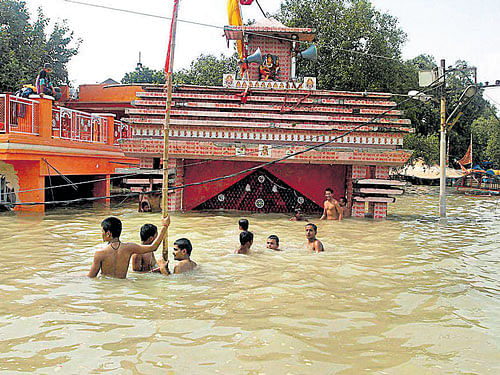 Children swim in the Ganga in front of a submerged temple in Allahabad. PTI