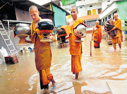 FLOODEDABODE: Buddhist monks move out of a monastery in flood- hit Bodhgaya on Wednesday. PTI
