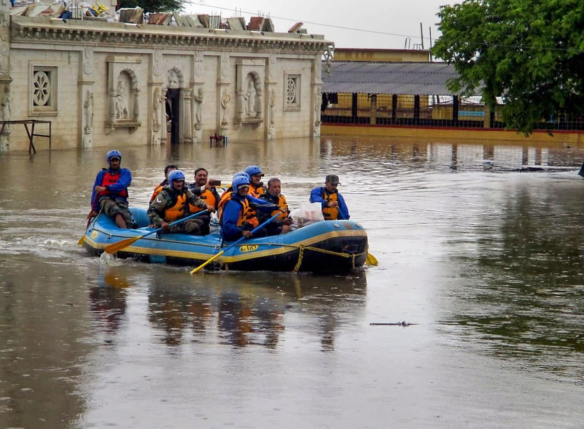 A rescue team moves through the water during coordinated relief and rescue operations by Army Forces in flood-affected areas of Masaguppi village in Belgaum district, Karnataka on Thursday. PTI photo