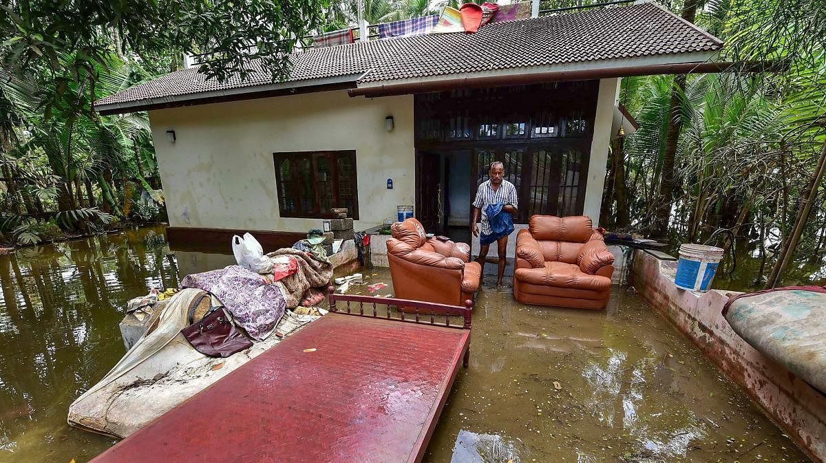  A man cleans up his house after flood water subsided, in Puthenvelikkara near Kochi. PTI photo