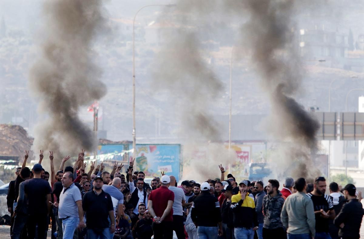  Lebanese protesters gather next to burning tyres to block the southern entrance of the capital of north Lebanon Tripoli, as anti-government demonstrations continued on November 12, 2019 across the country. (AFP Photo)