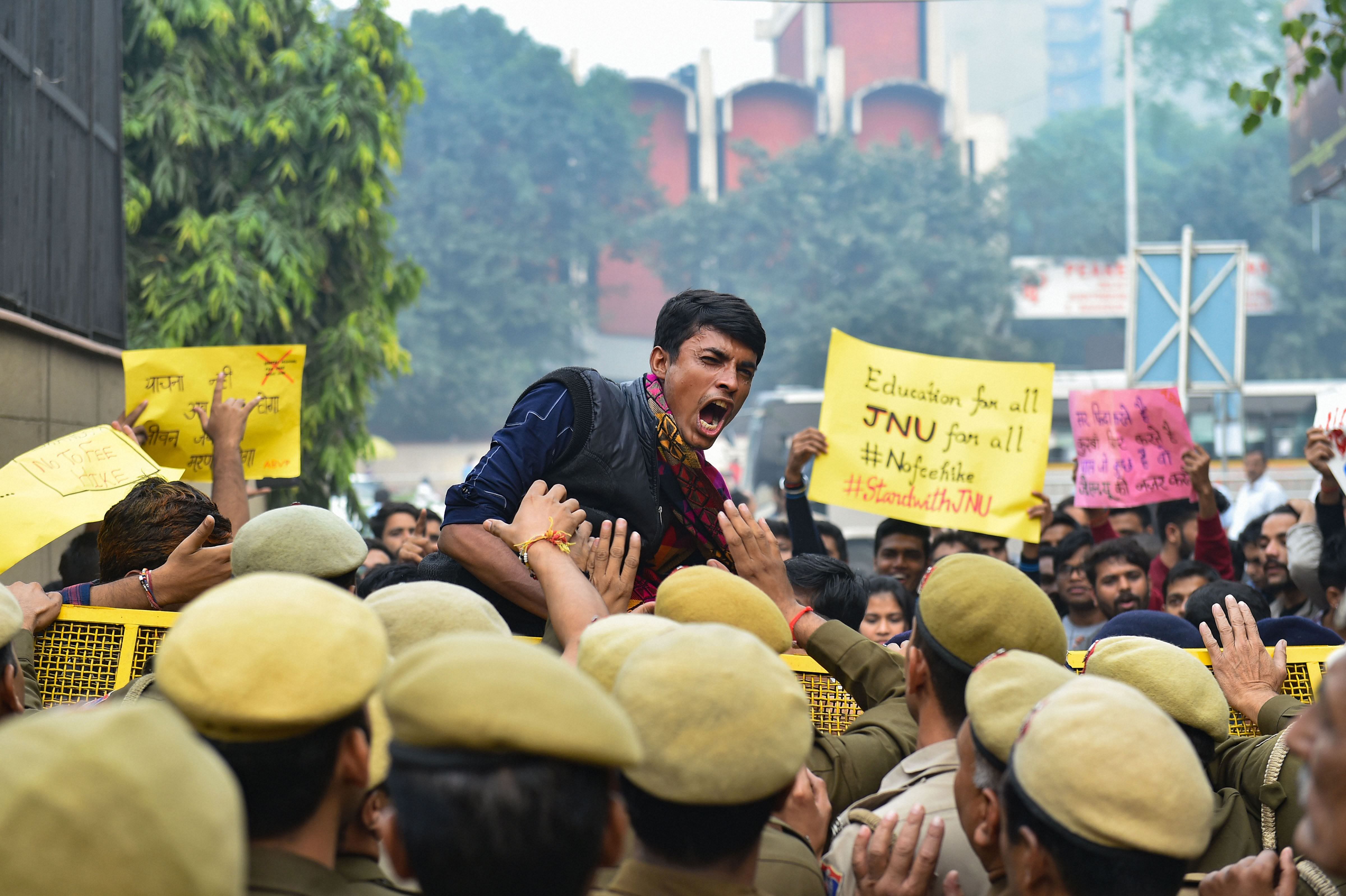 Police stop JNU students who were staging a protest over the hostel fee hike outside the UGC office at ITO in New Delhi. (PTI Photo)