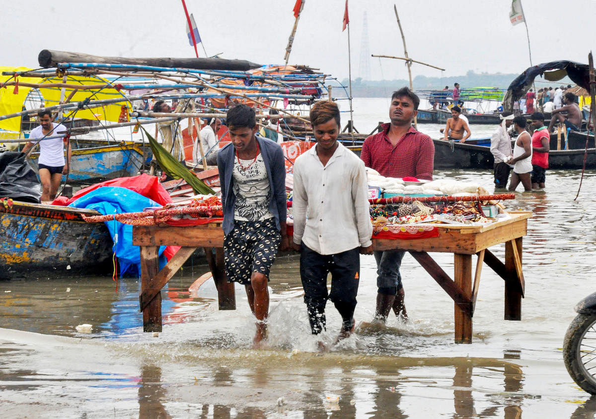 Shopkeepers shift their stalls after an increase in water level at Sangam following monsoon rainfall, in Prayagraj, Thursday, July 11, 2019. (PTI Photo)