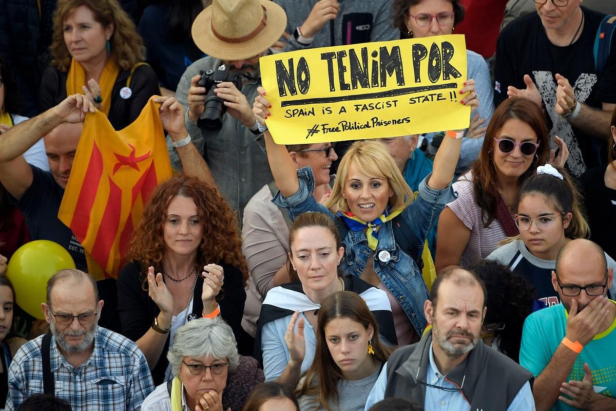 A protester holds up a sign reading "We are not afraid" during a pro-independence demonstration called by Catalan National Assembly (ANC) and Omnium Cultural organisations, against the conviction of Catalan separatist leaders for the 2017 attempted secession, in Barcelona, on October 26, 2019. (Photo by LLUIS GENE / AFP)