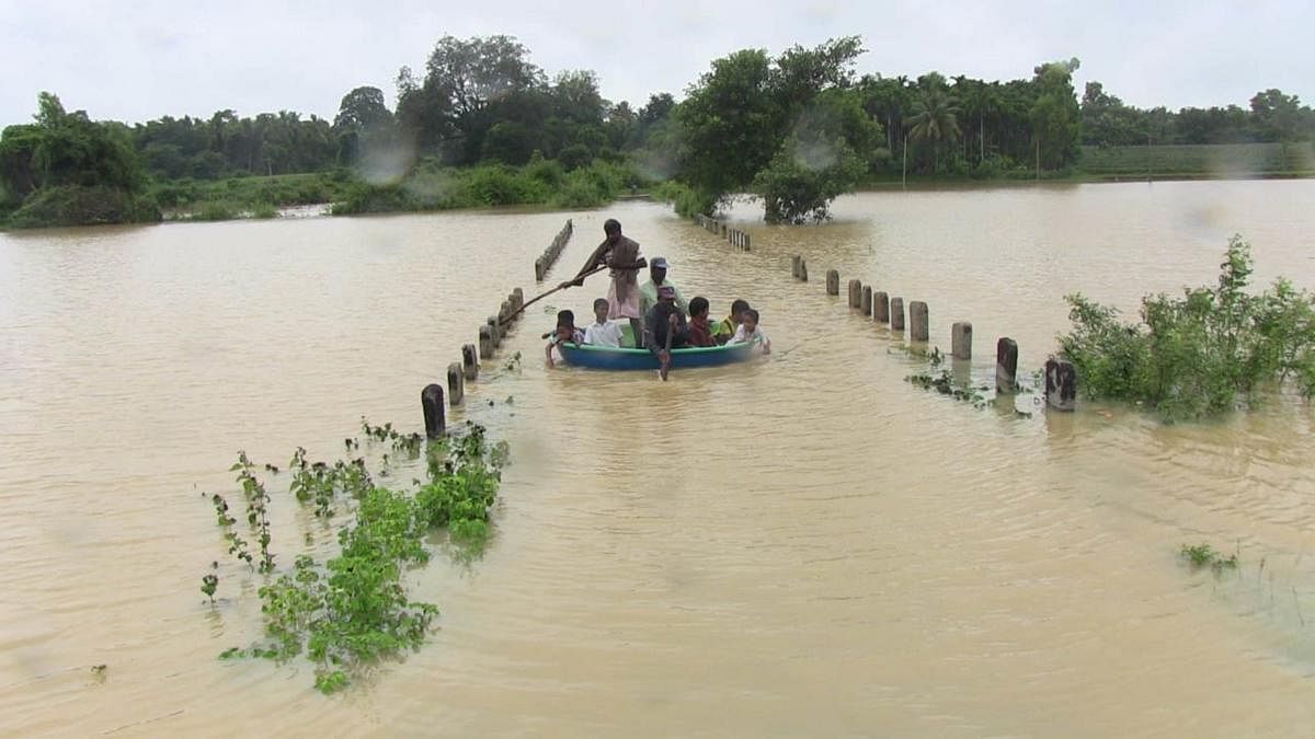 People use a coracle to cross the swollen River Varada near Banavasi in Sirsi taluk of Uttara Kannada district. DH Photo