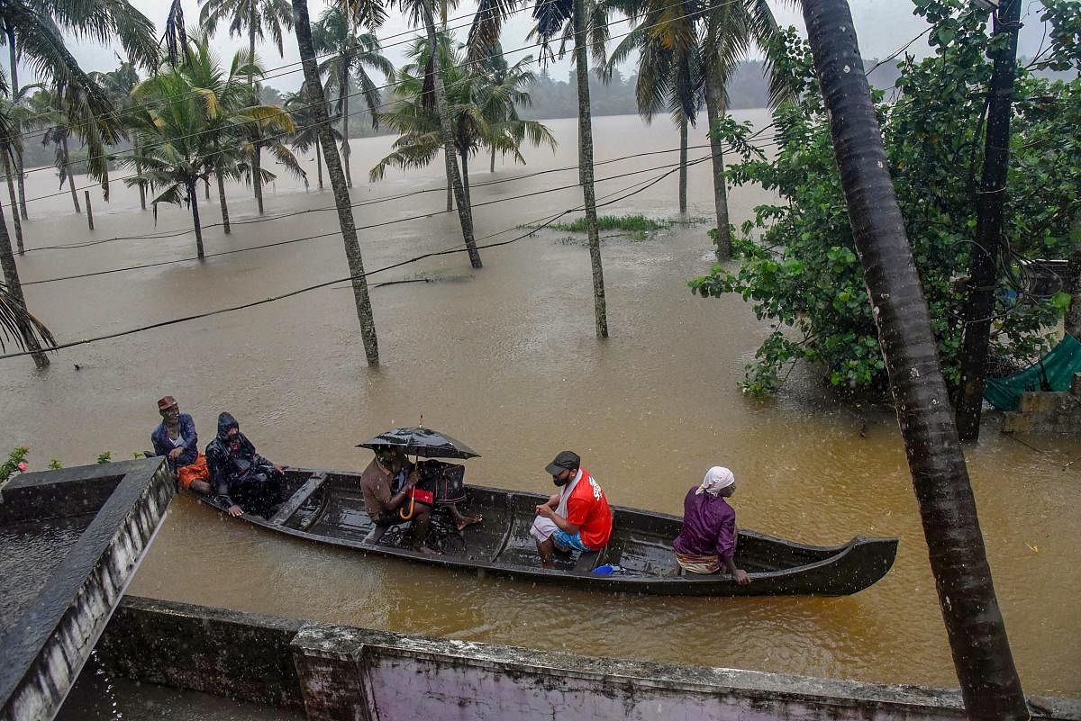 Rescue officials assist villagers out of a flooded area following heavy monsoon rainfall, near Kochi on Wednesday. PTI Photo