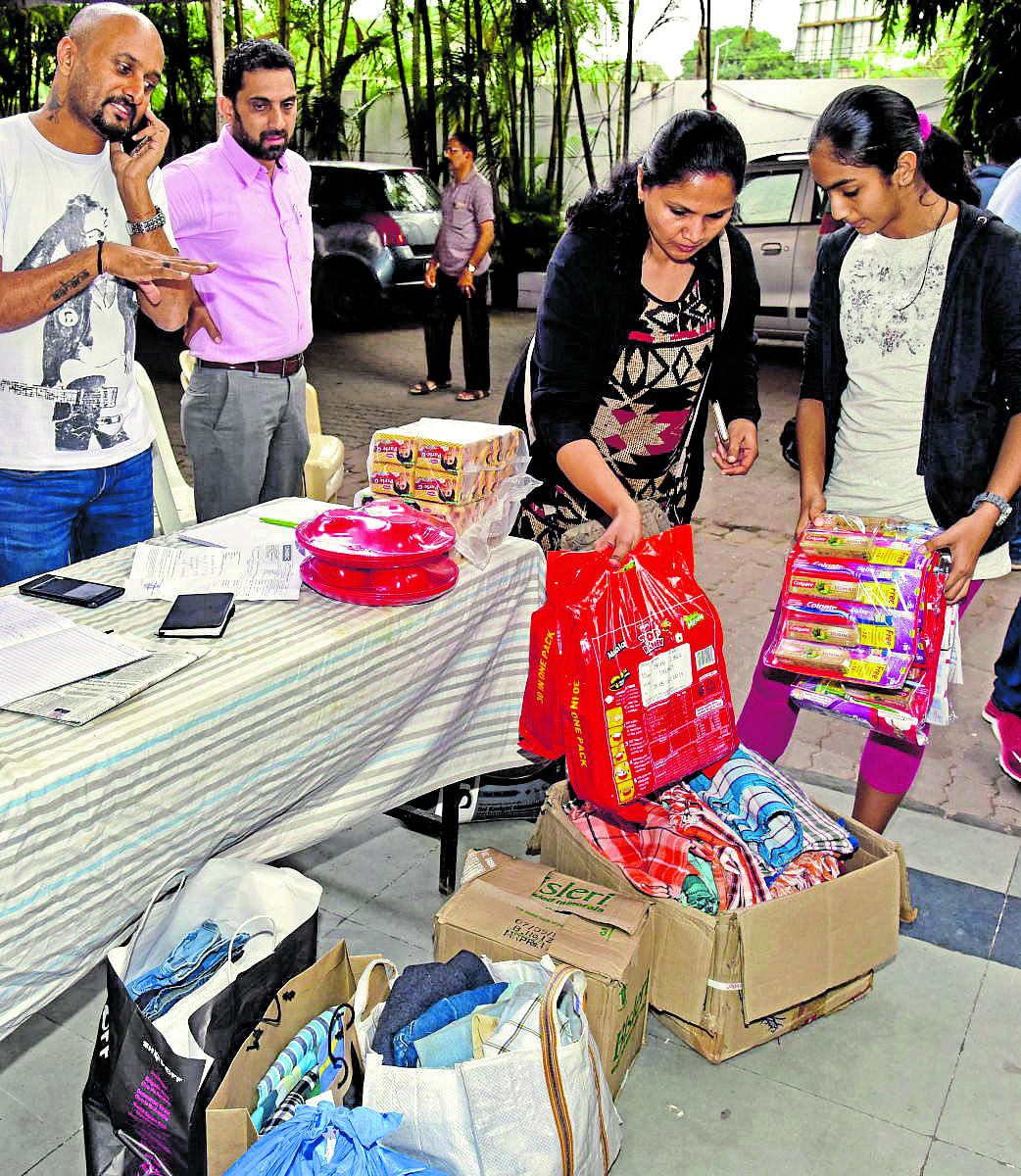 A Kodava Samaja member donates relief materials at the Samaja premises at Vasanthnagar in Bengaluru on Friday. DH PHOTO