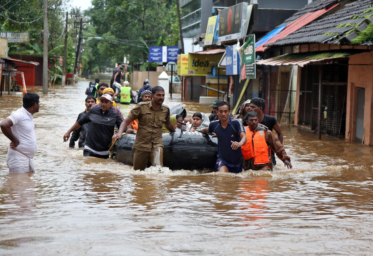 Rescuers evacuate people from a flooded area to a safer place in Aluva in Kerala. (Reuters Photo)