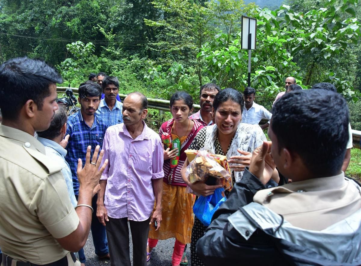 A woman requests police to allow her to travel from Koinadu to Jodupala in Kodagu district on Monday.