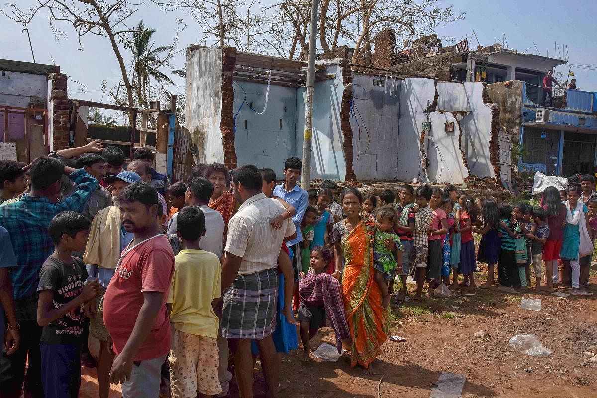 Mandasa: Cyclone 'titli' affected people wait to receive food at Mandasa in Andhra Pradesh, Sunday, Oct 14, 2018. (PTI Photo) (PTI10_14_2018_000123B)